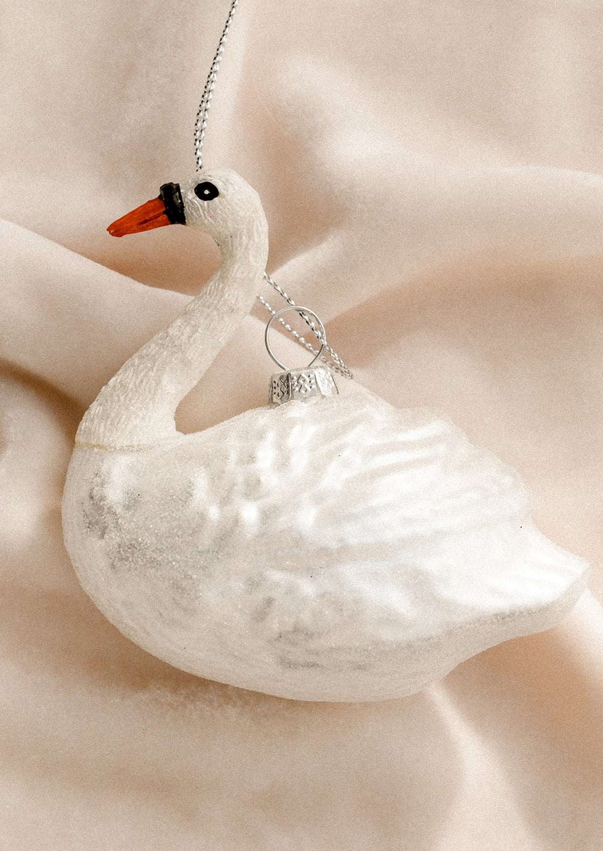 A decorative glass ornament depicting a white swan.