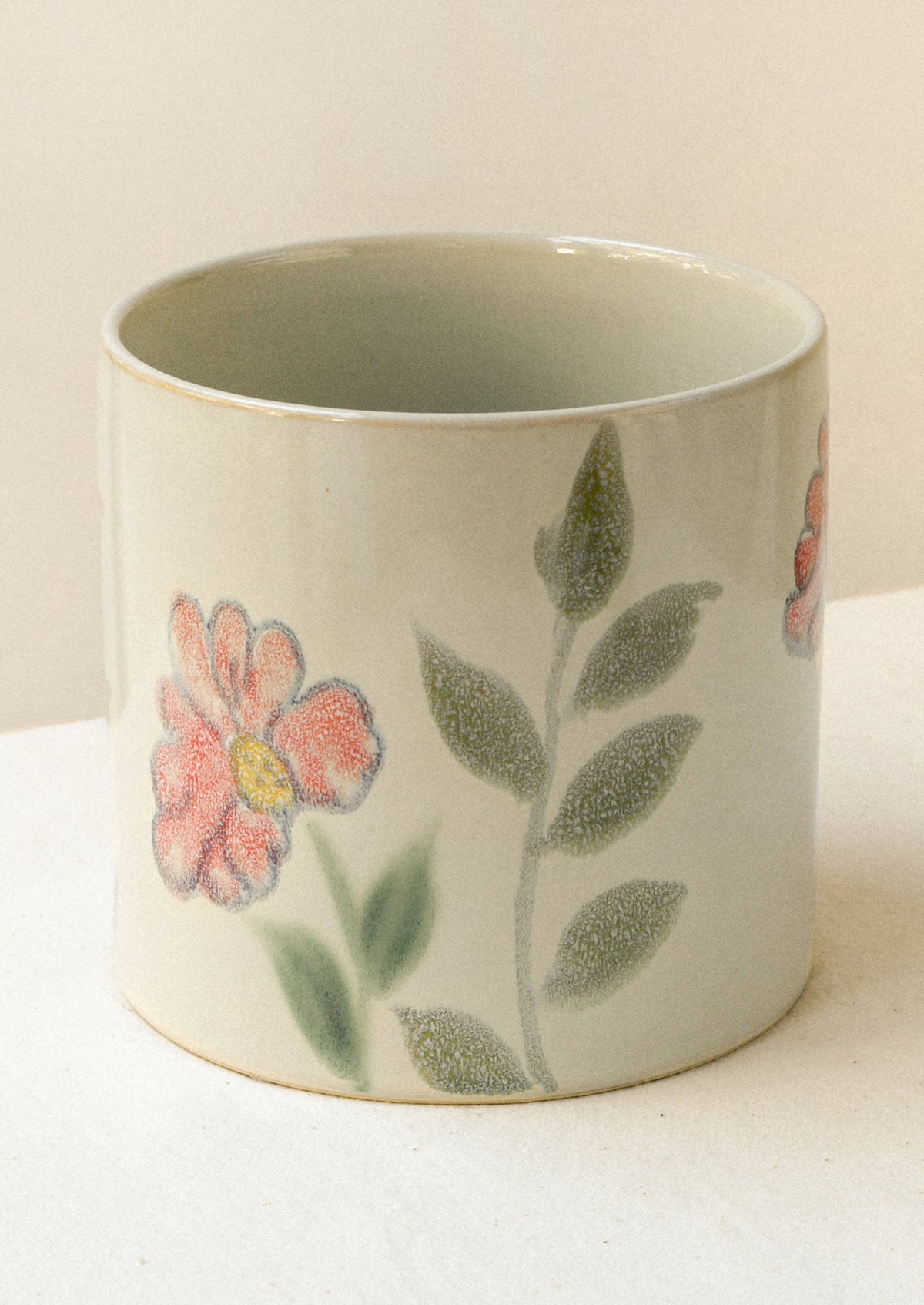 A ceramic planter with a painted floral watercolor design.