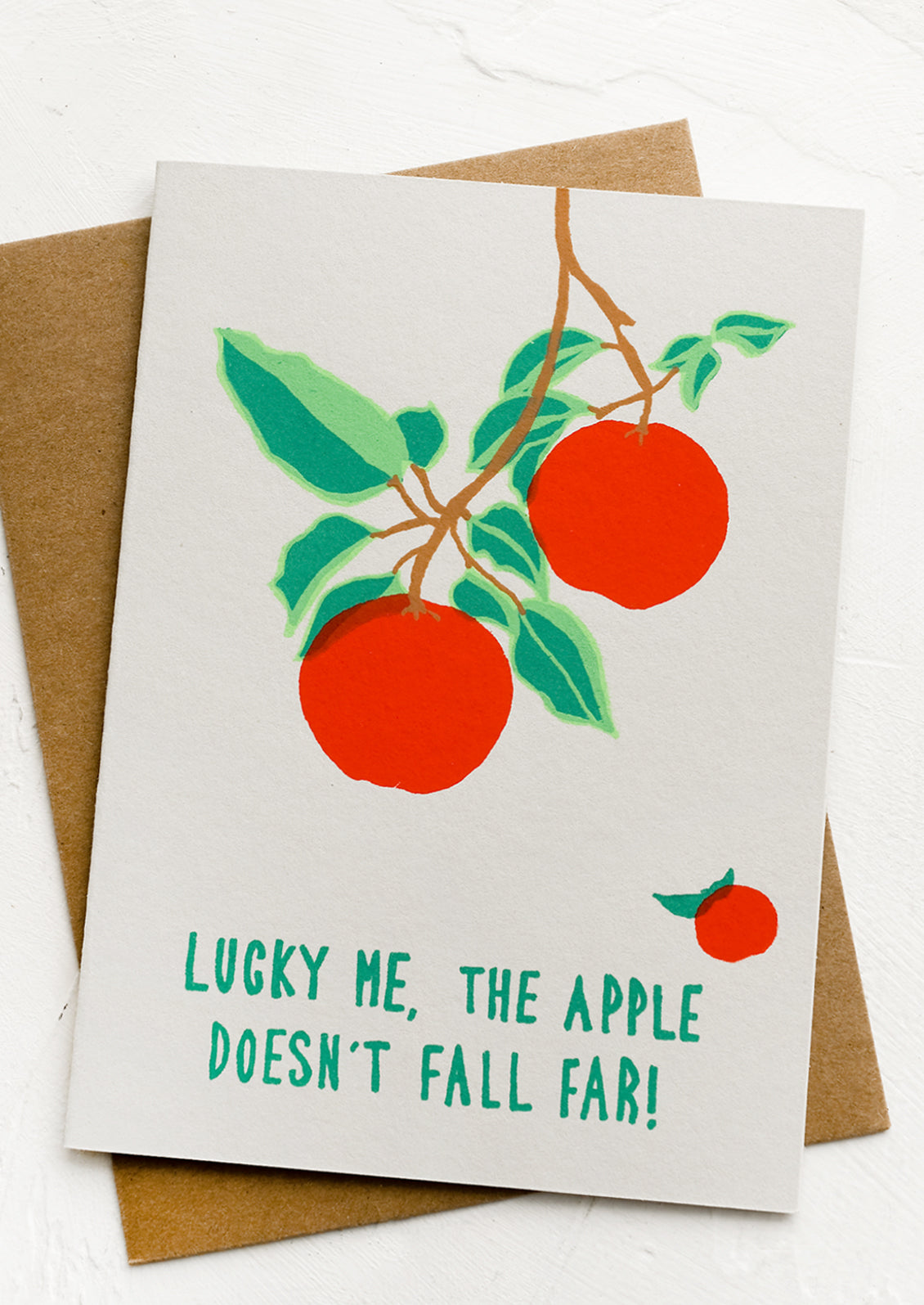 A greeting card reading "Lucky me, the apple doesn't fall far!".