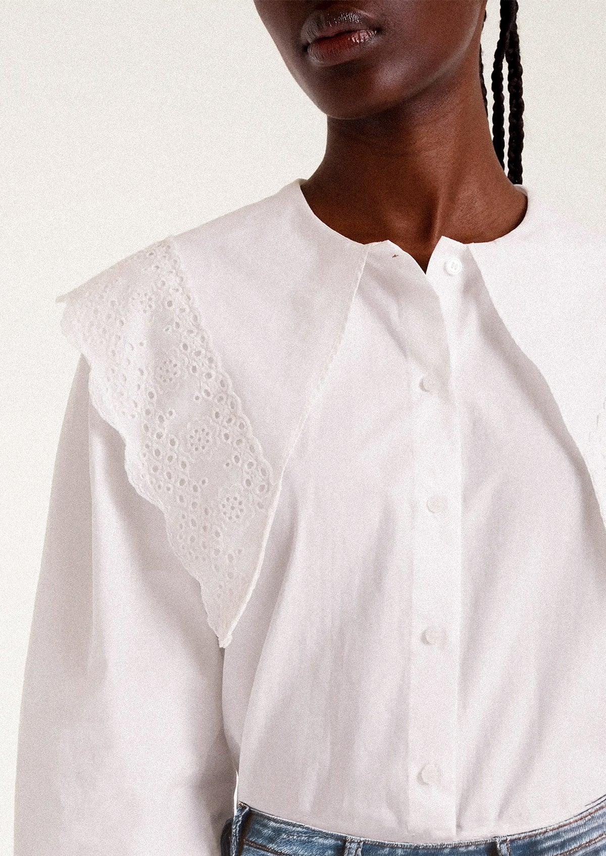 White blouse with intricate collar design worn by a person.
