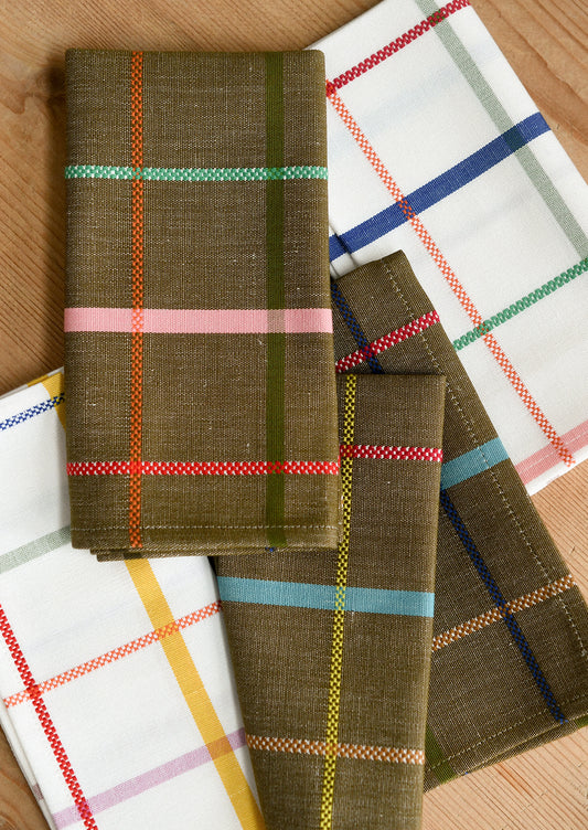 Folded plaid napkins arranged on a wooden surface. 