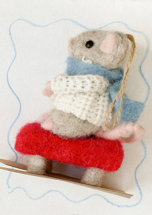 A decorative ornament of a mouse on skis.