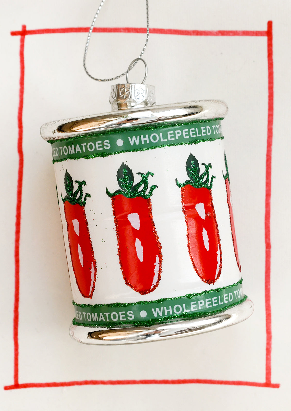 A glass ornament depicting a can of whole peeled tomatoes.