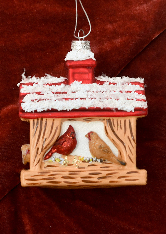 A glass ornament depicting a bird feeder with cardinal and other bird.