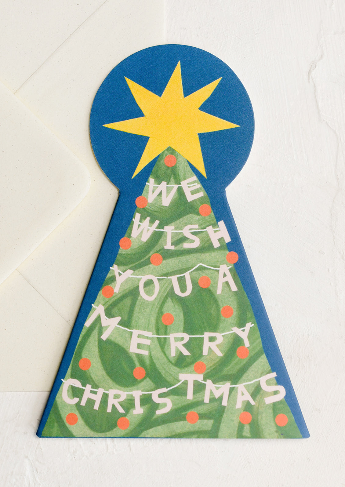 A diecut card in the shape of a tree with large yellow star at top, text reads "We wish you a merry Christmas".