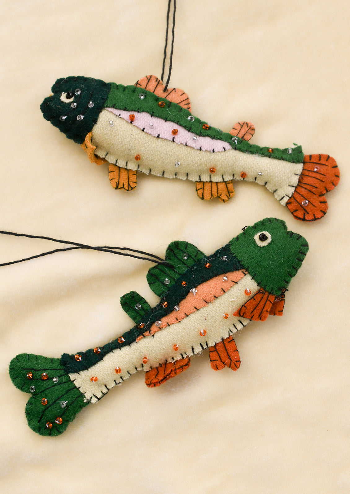 Two fish-shaped ornaments on a beige background