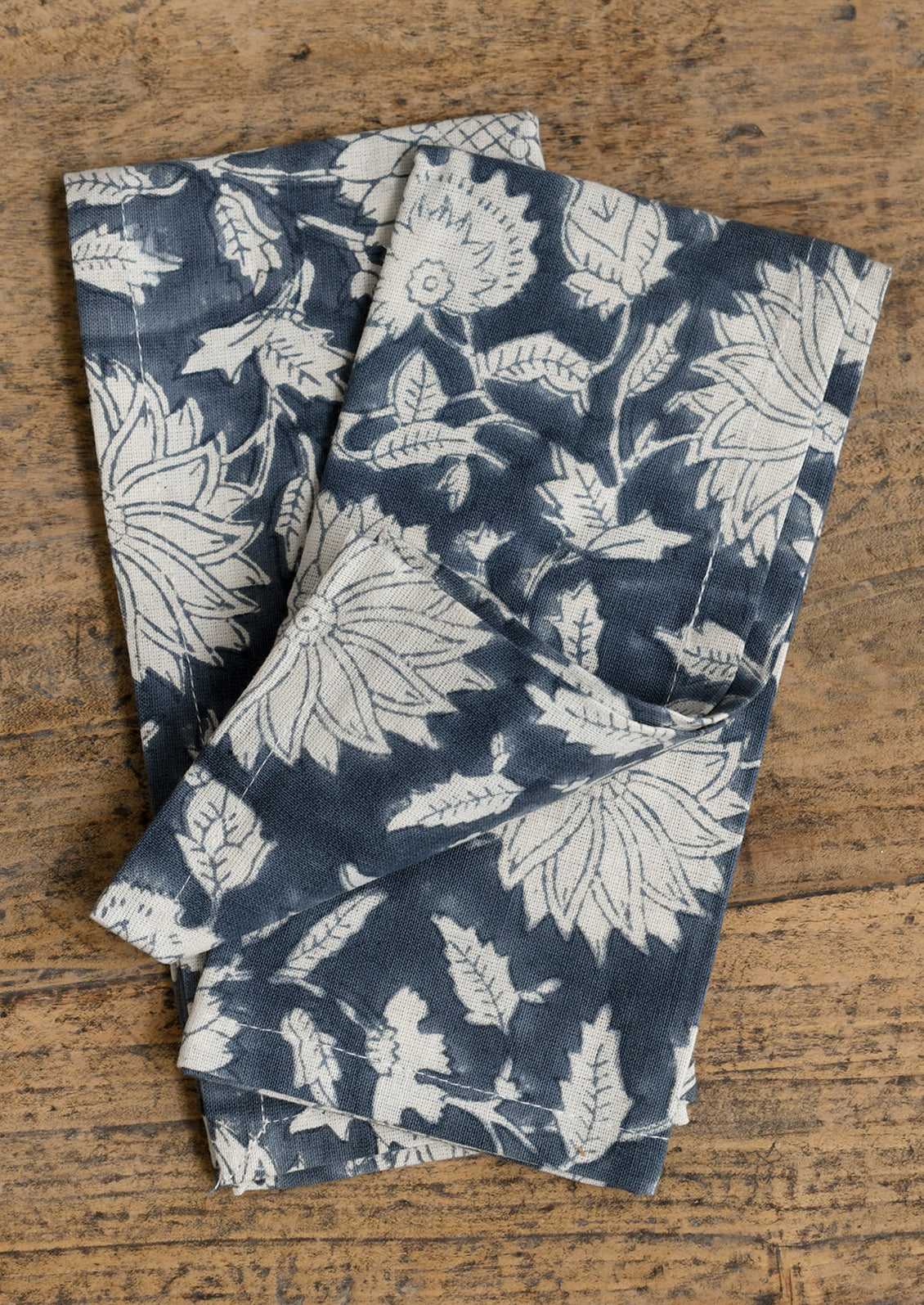A pair of floral patterned napkins in steel blue and white.