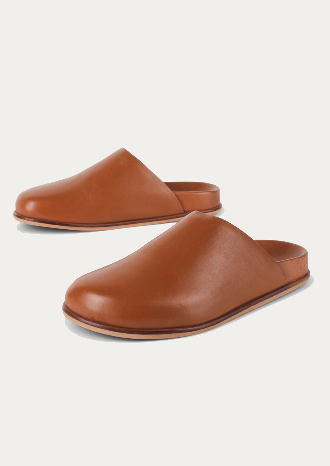 A pair of caramel leather closed toe slip-on mule shoes.