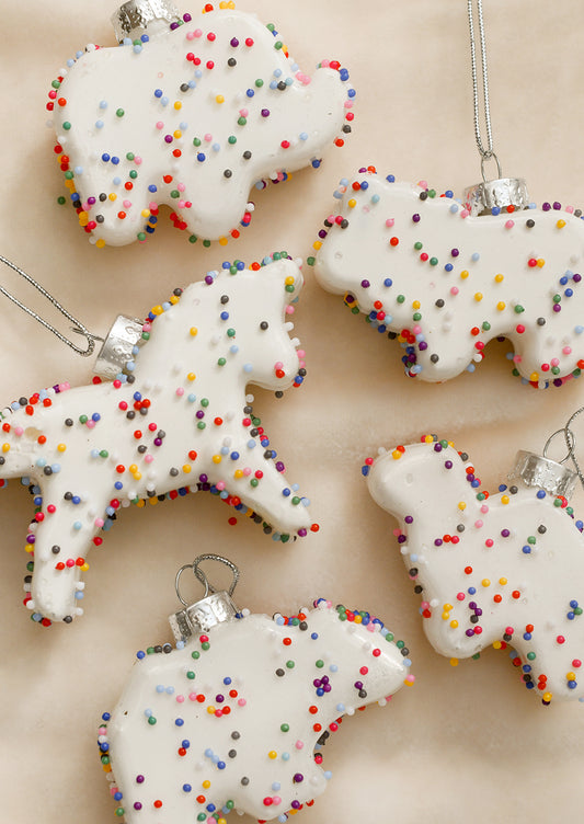 Ornaments that look like white frosted animal cookies with confetti sprinkles.