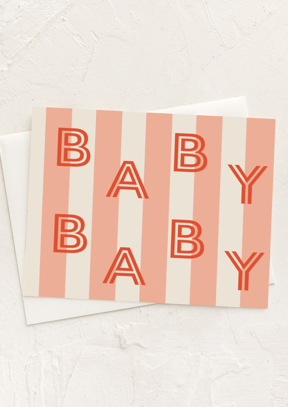 A greeting card with peach stripes reading "BABY BABY" in red letters.