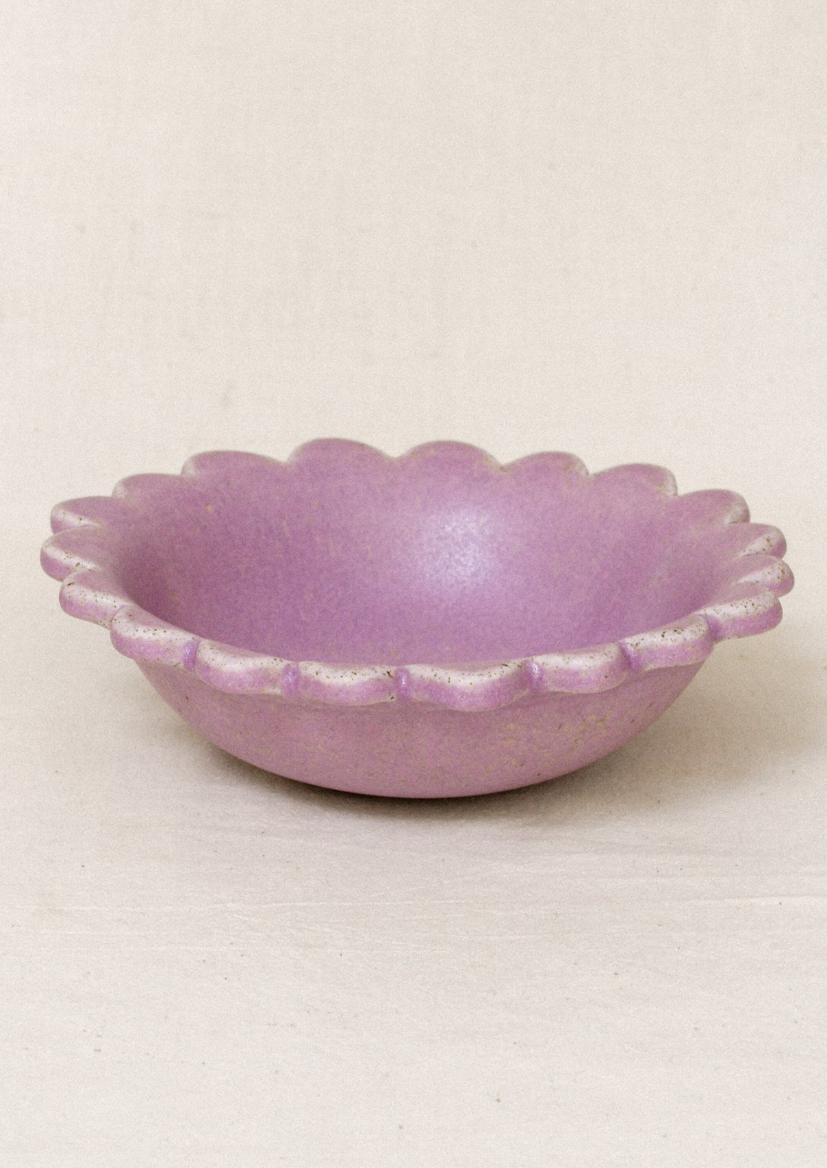 A ceramic scalloped edge bowl in a lilac color.