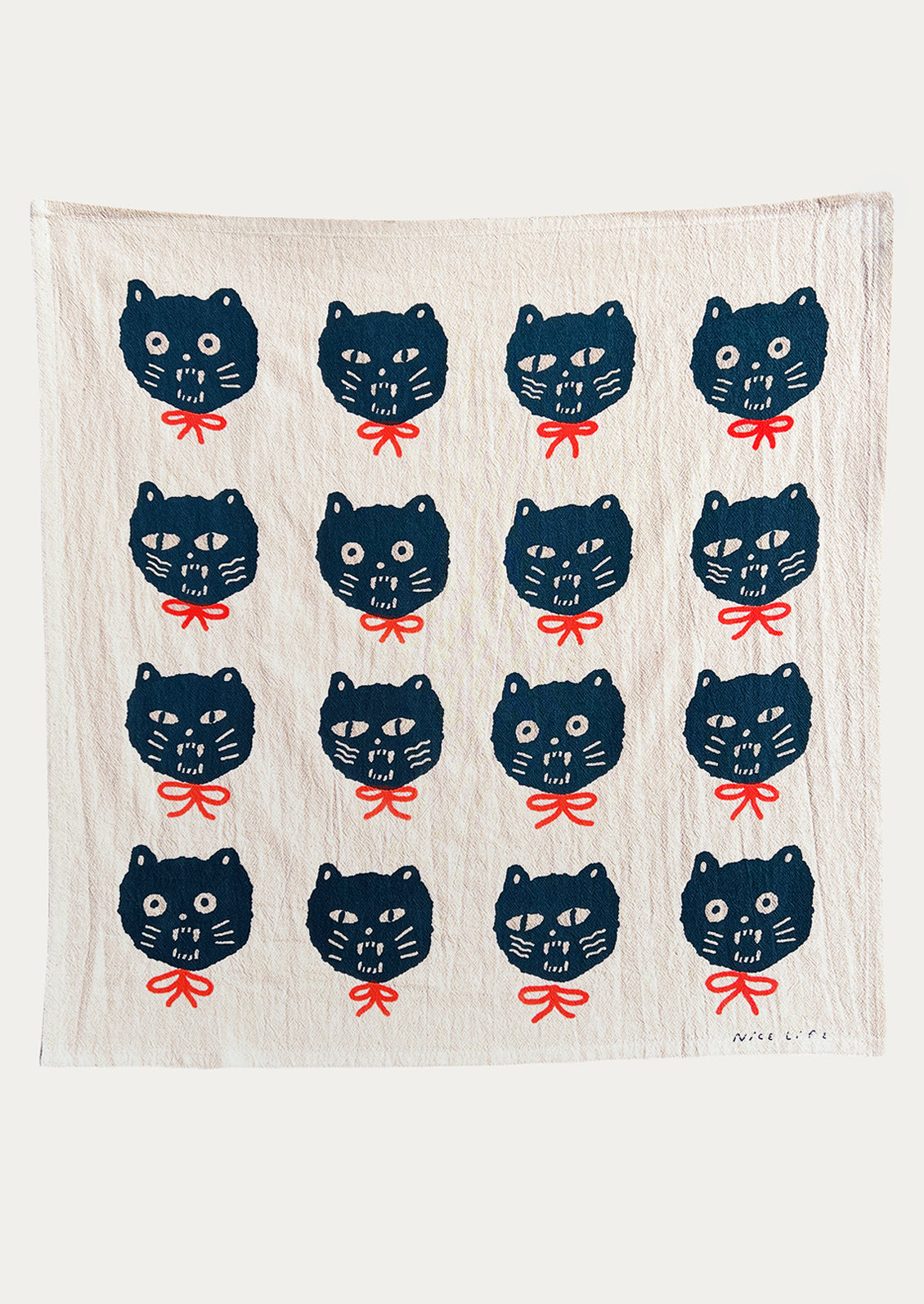 A tea towel with repeating cat face motif.