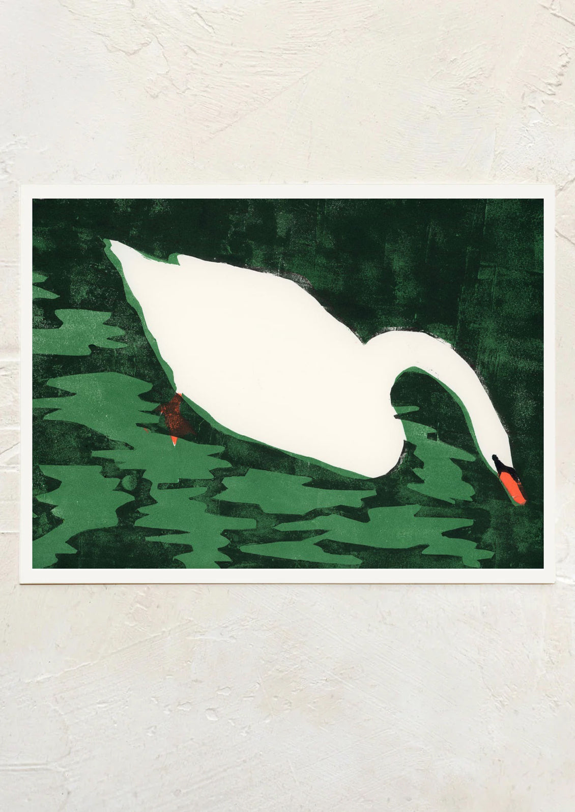 Framed artwork of a white swan on green water with a textured wall background