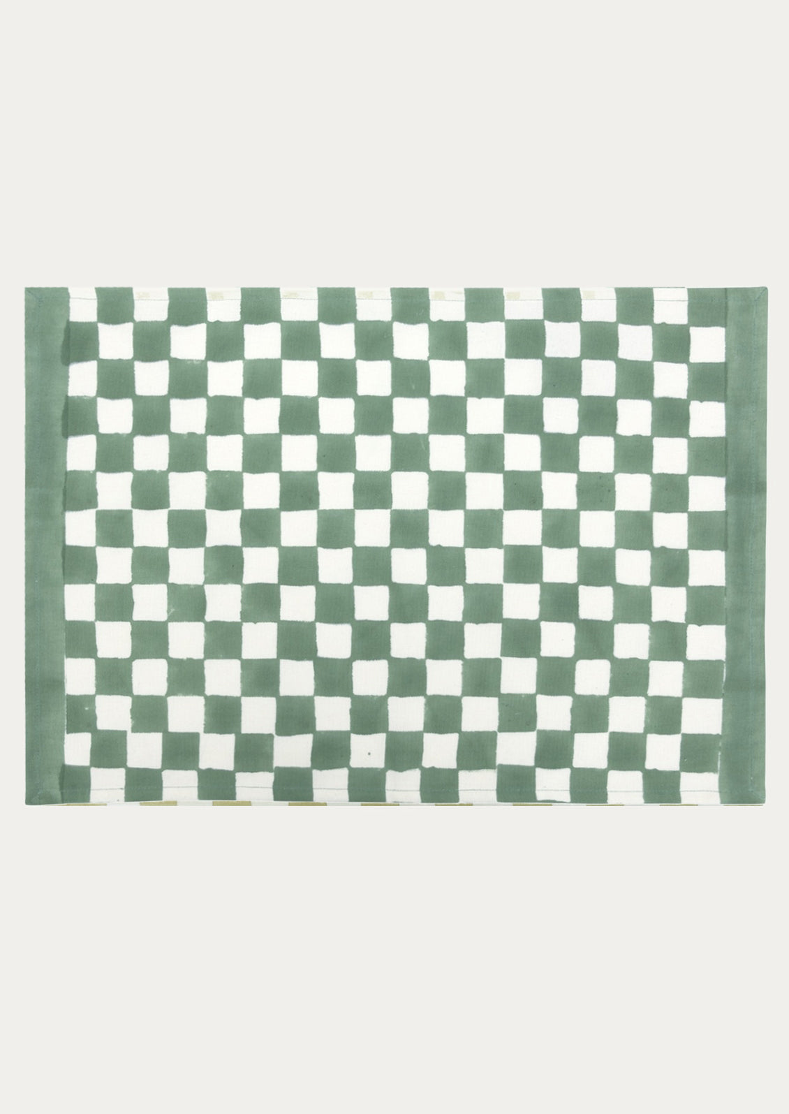 A block printed placemat with checkered pattern in clover green.
