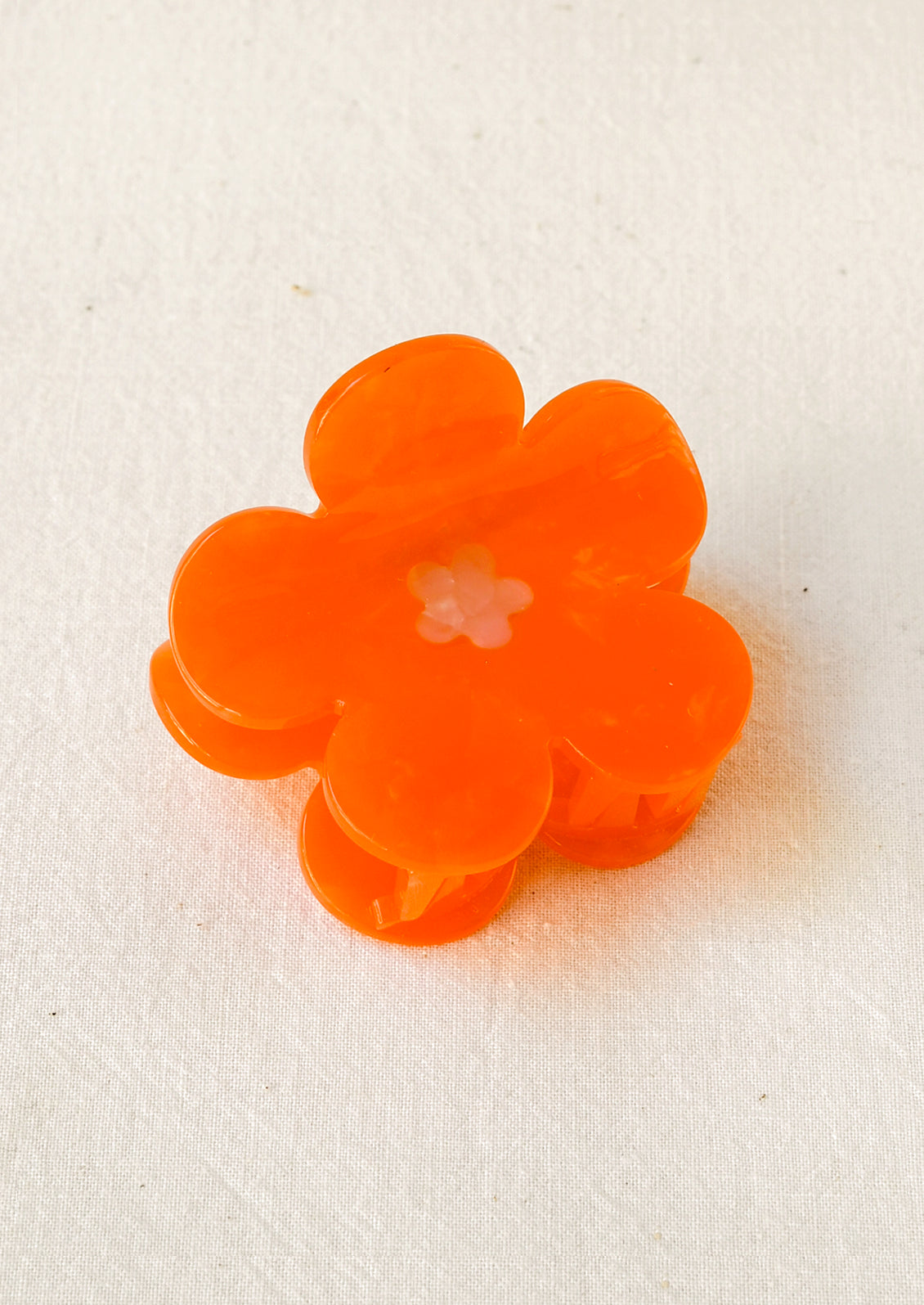 A hair claw depicting an orange cosmos flower.
