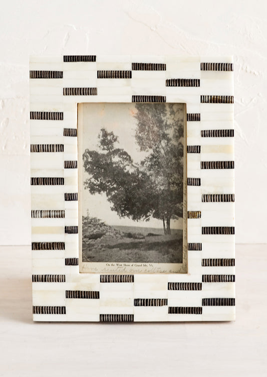 A tabletop picture frame in black and white dashes pattern.