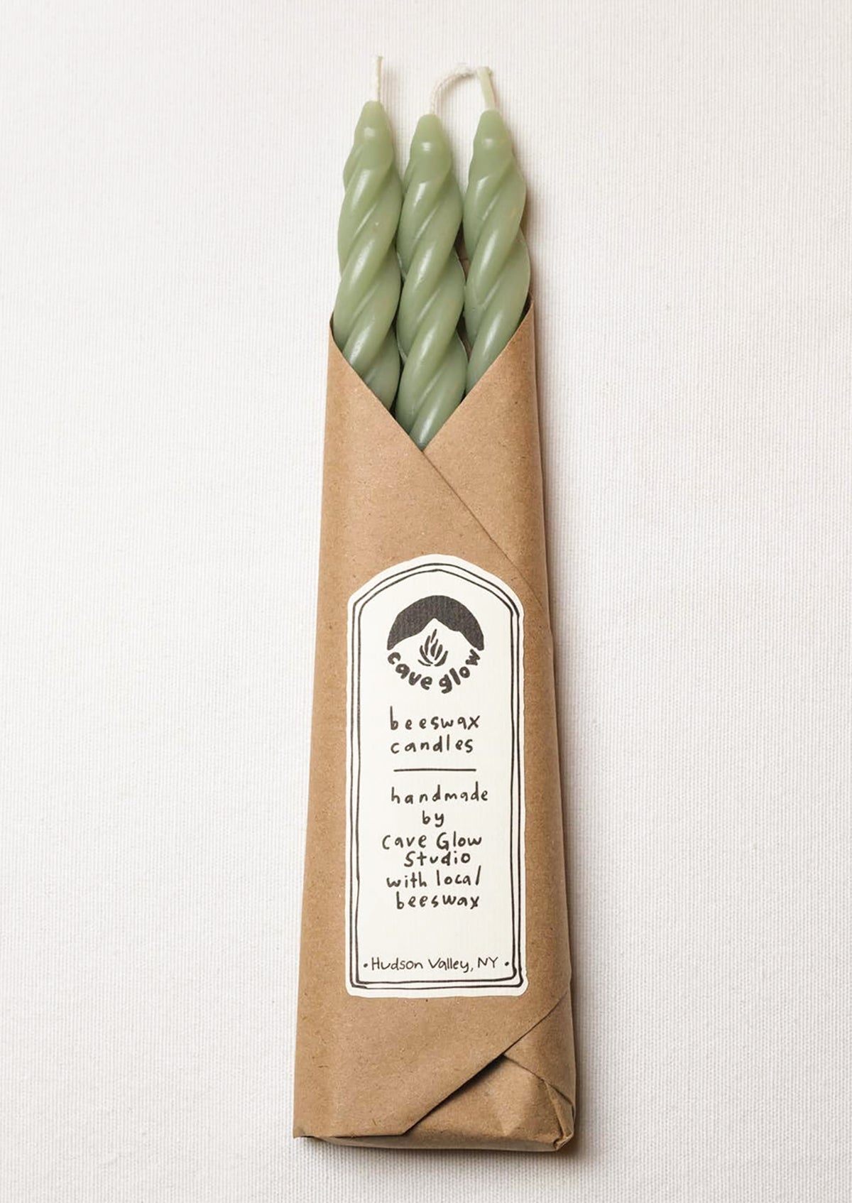 A set of three spiral textured taper candles in sage green color.