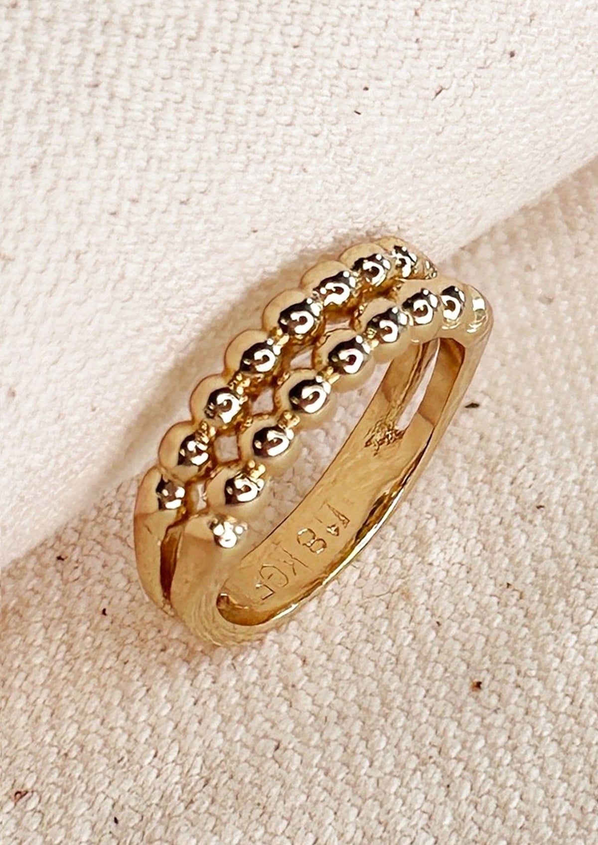 A gold ring with look of double beaded band.