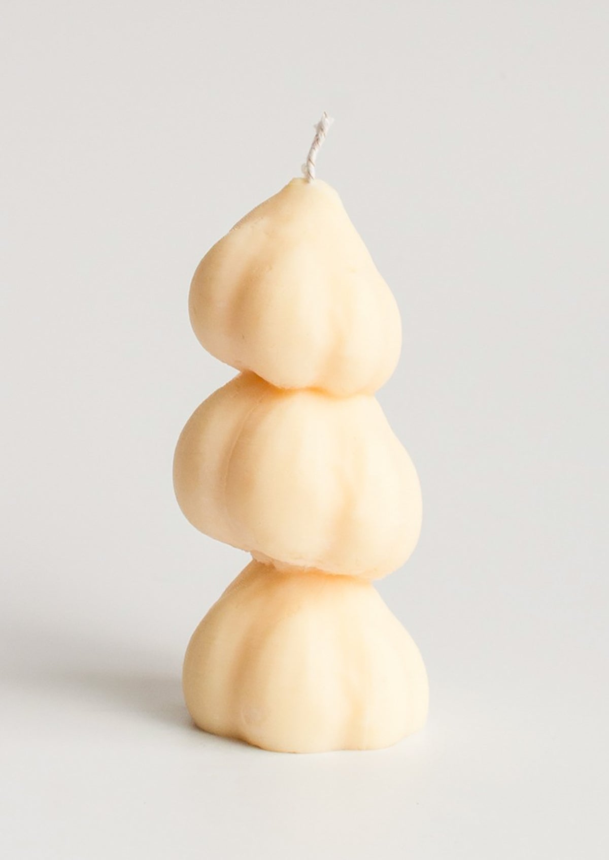 A candle in the shape of three stacked garlic bulbs.