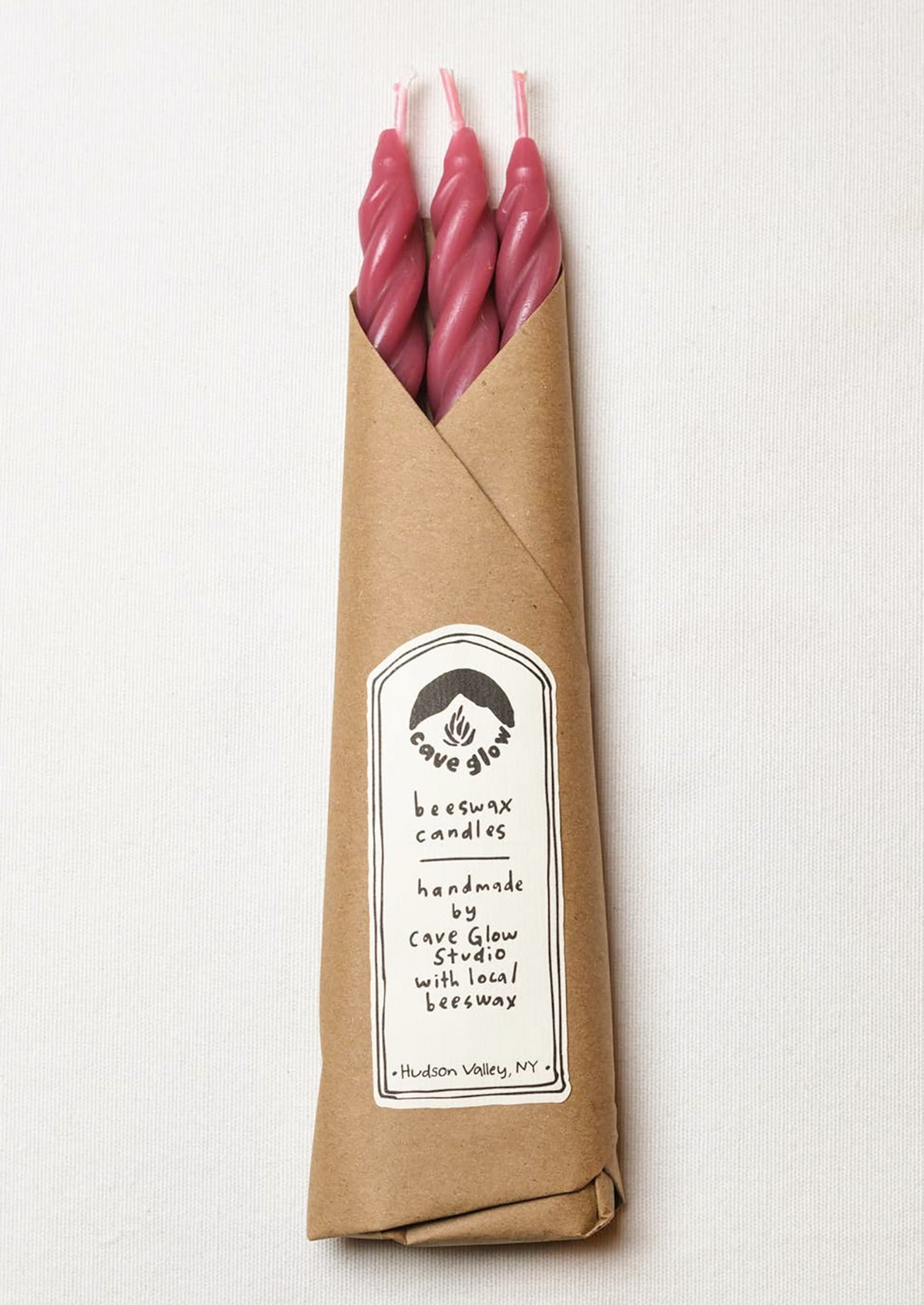 A set of three spiral textured taper candles in berry color.