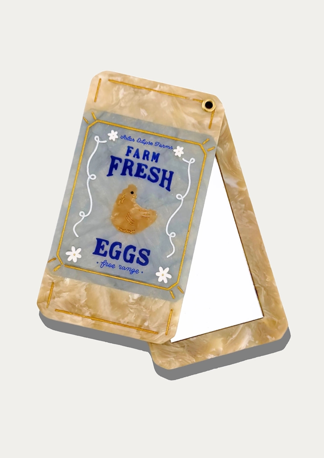 A compact mirror depicting a carton of eggs.
