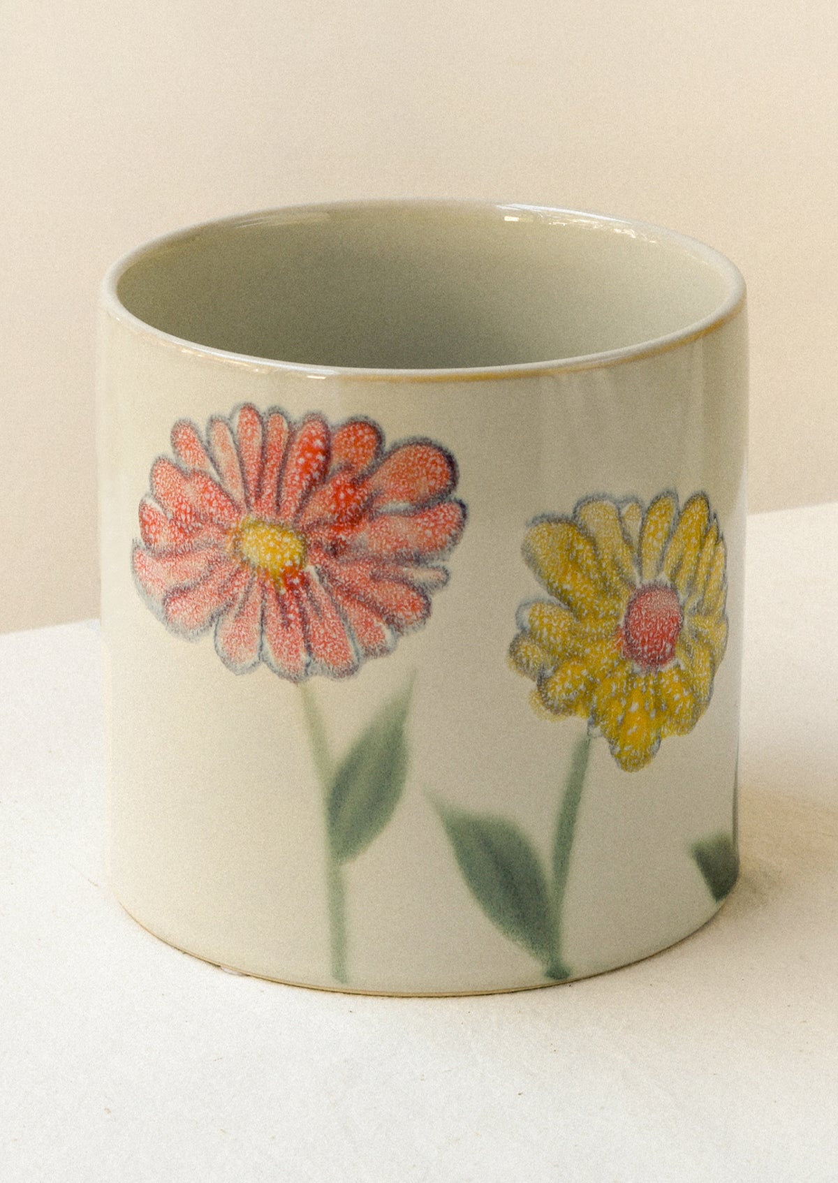 A ceramic planter with a painted floral watercolor design.