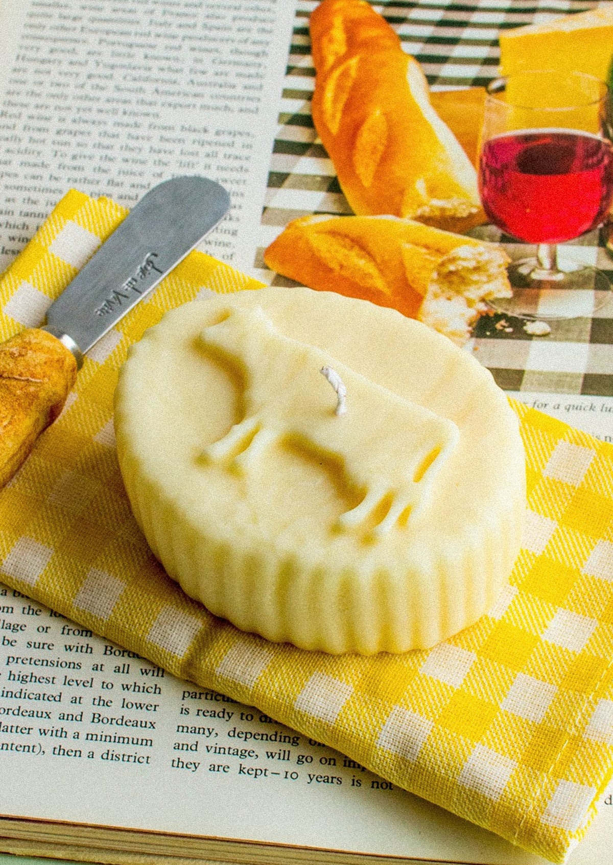 A realistic looking candle in the shape of french butter with cow shape.