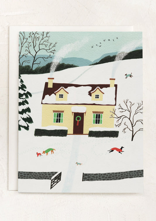 A greeting card with illustration of a house on a hill with a snowy, winter scene.