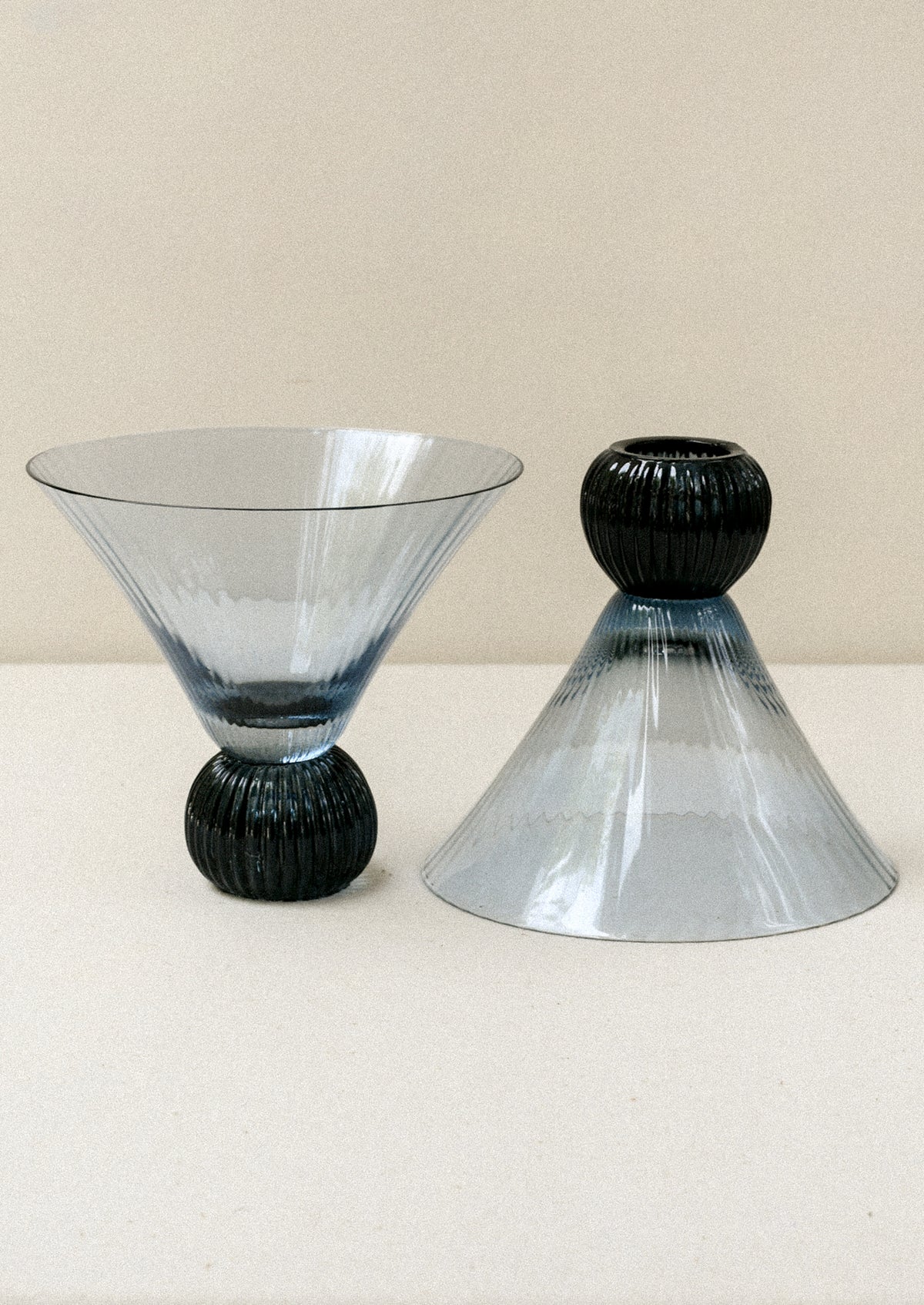Two short blue glass martini glasses with ribbed, flared shape.