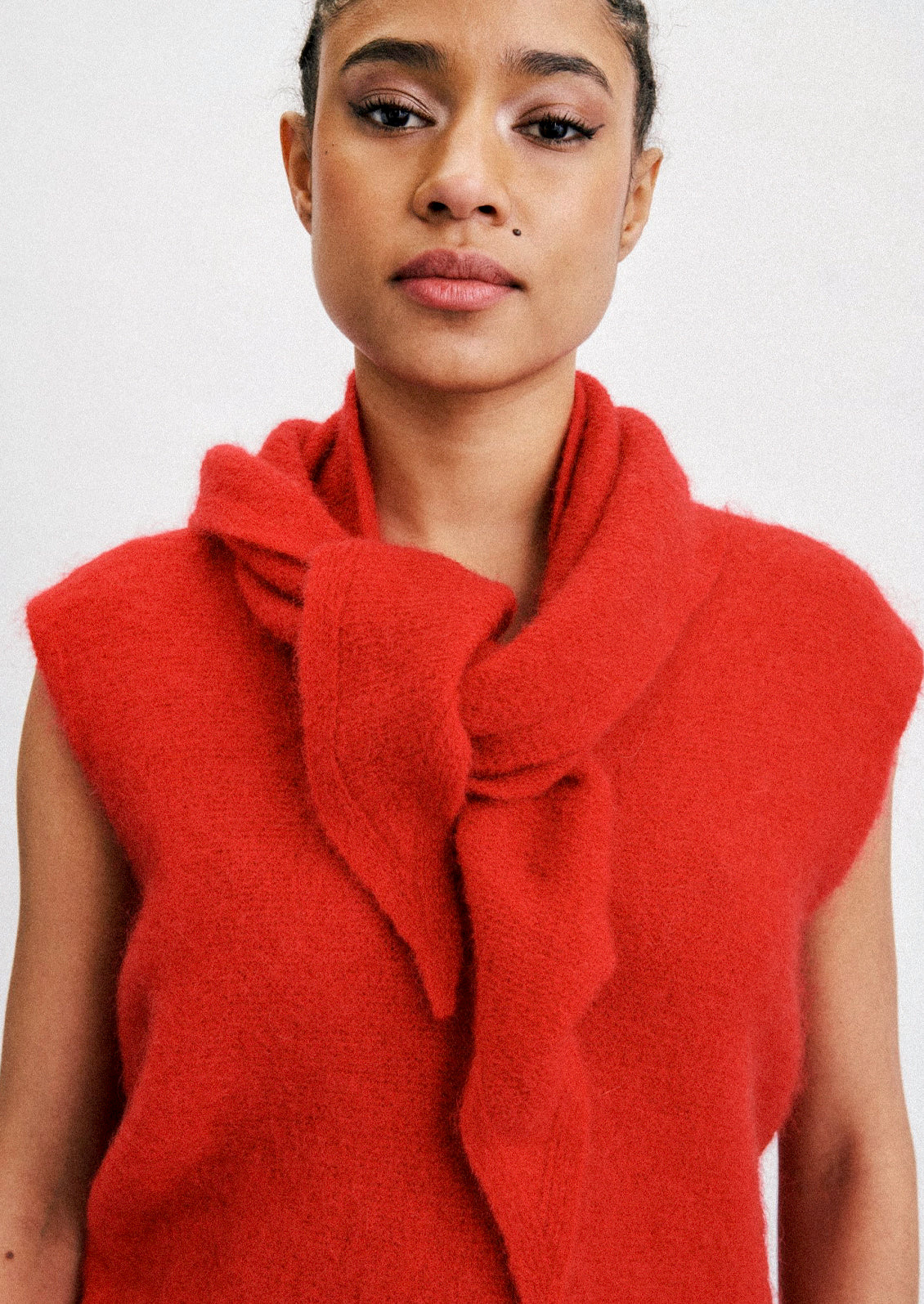 A woman wearing a mohair blend scarf and top in a cherry red color.