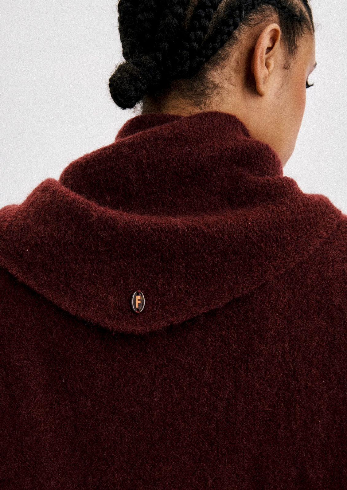 A woman wearing a mohair blend scarf and top in a deep oxblood color.