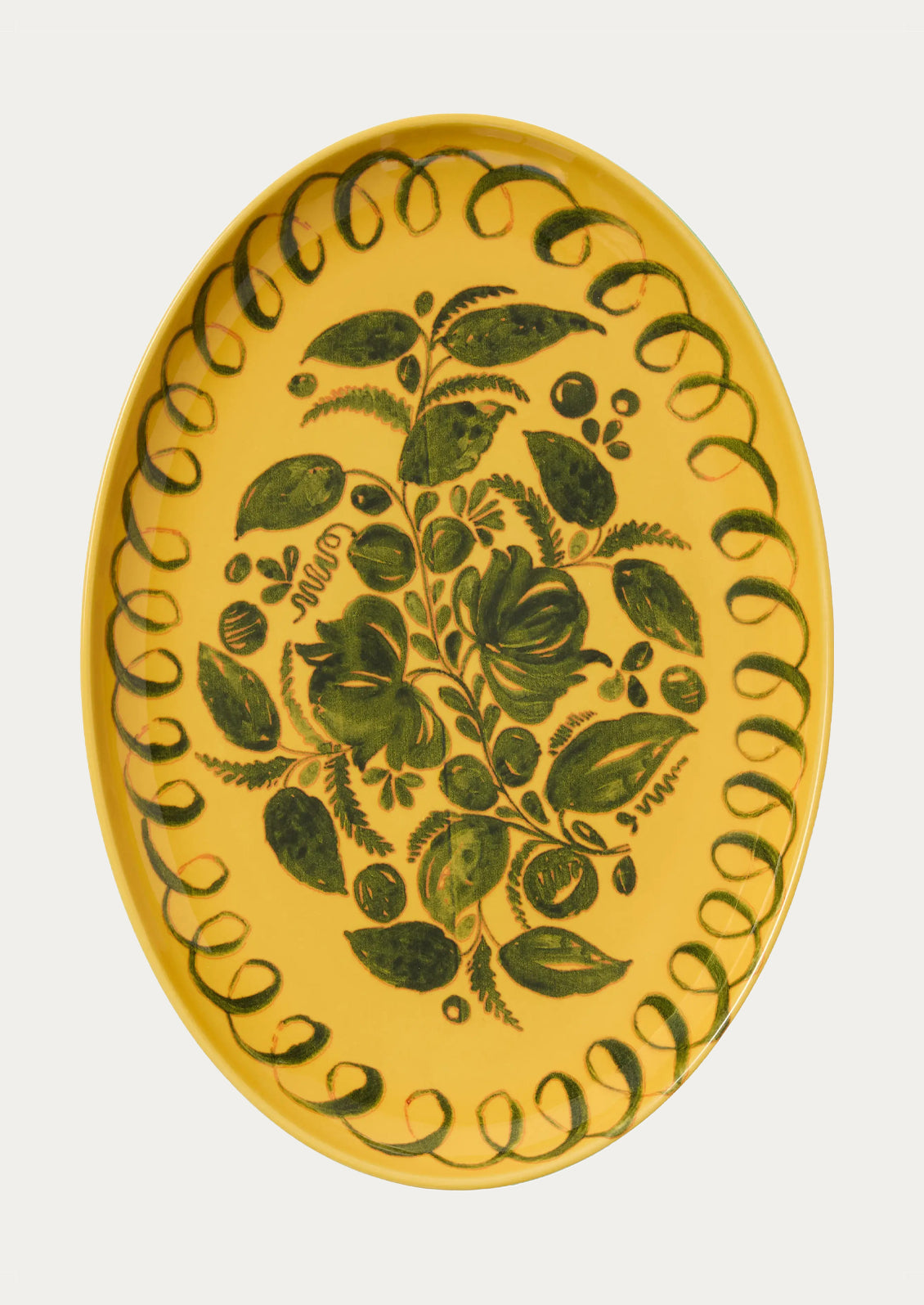 Decorative plate with green leaf pattern on a yellow background