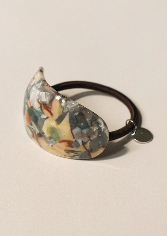Decorative hair tie with an abstract pattern on a beige background