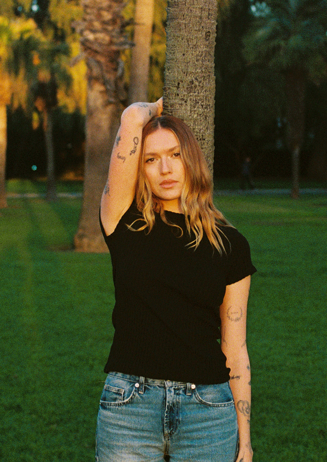 A woman wearing a black pointelle short sleeve tee.