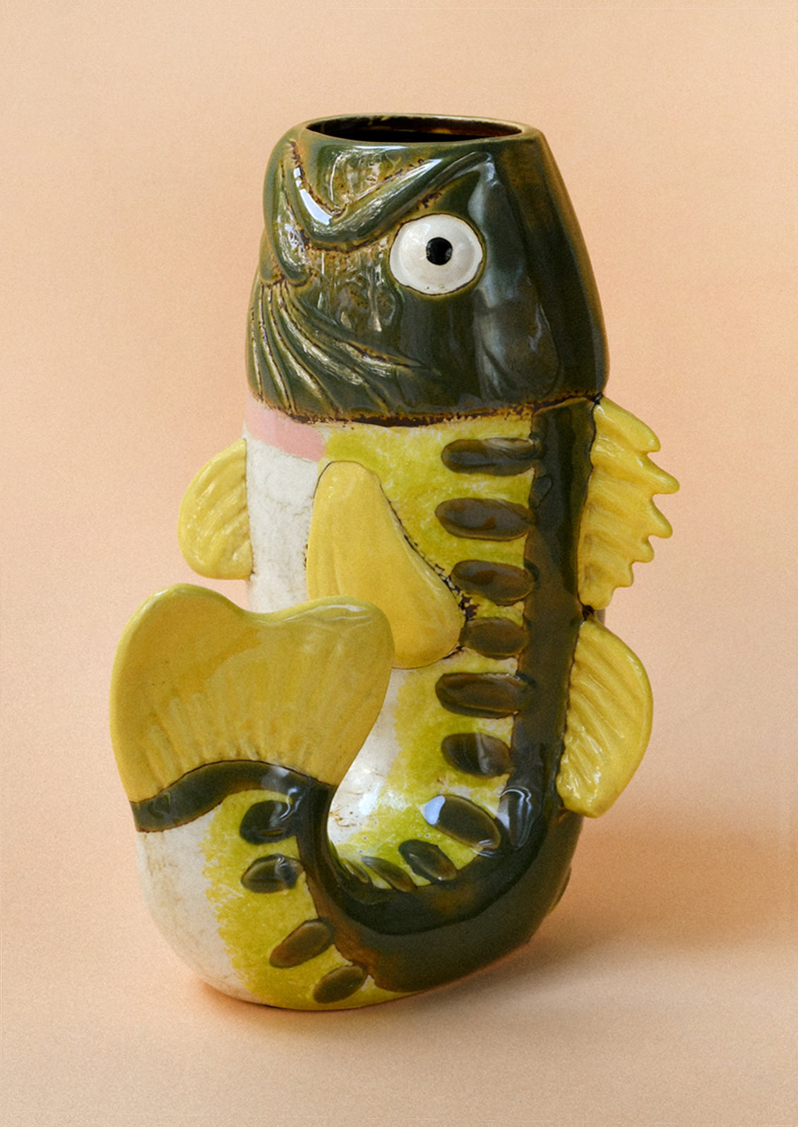 A ceramic vase in the shape of a green and yellow trout.