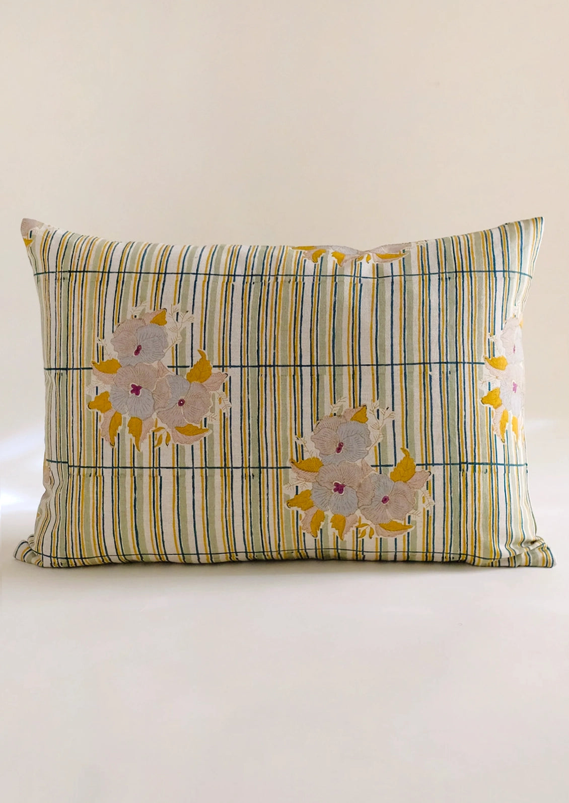 A throw pillow with stripe and floral pattern.