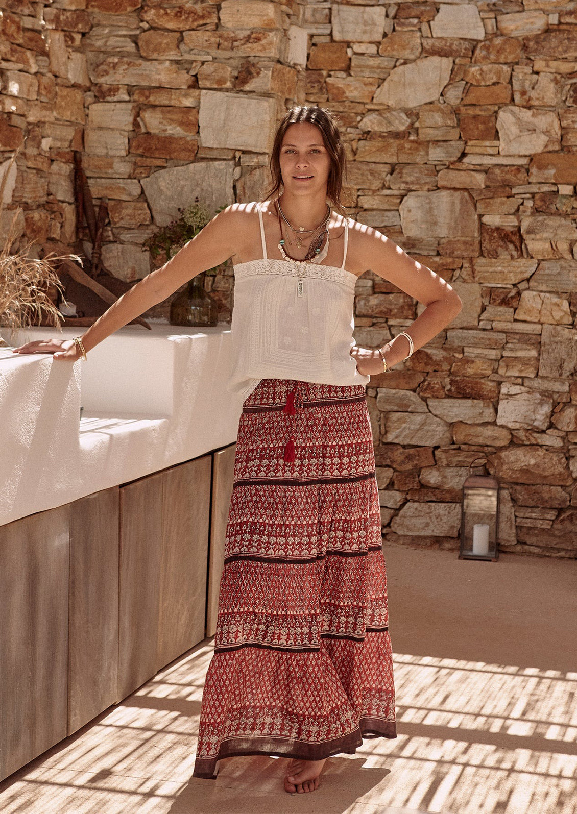 A woman wearing a square neck cami tank top in white with tonal embroidery.