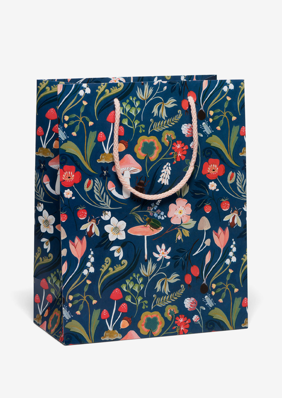 A printed gift bag with mushroom and floral print on dark blue background.