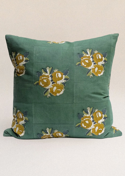 A block printed throw pillow in forest green with ochre floral print.