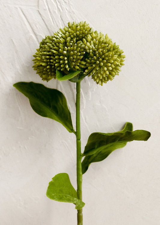 A faux floral pick resembling a green sedum.