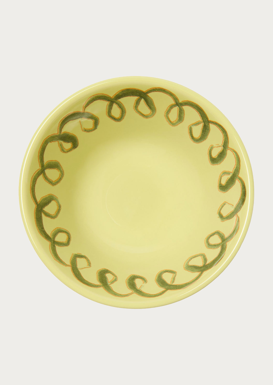 A greenish yellow bowl with a squiggle design along the edge.