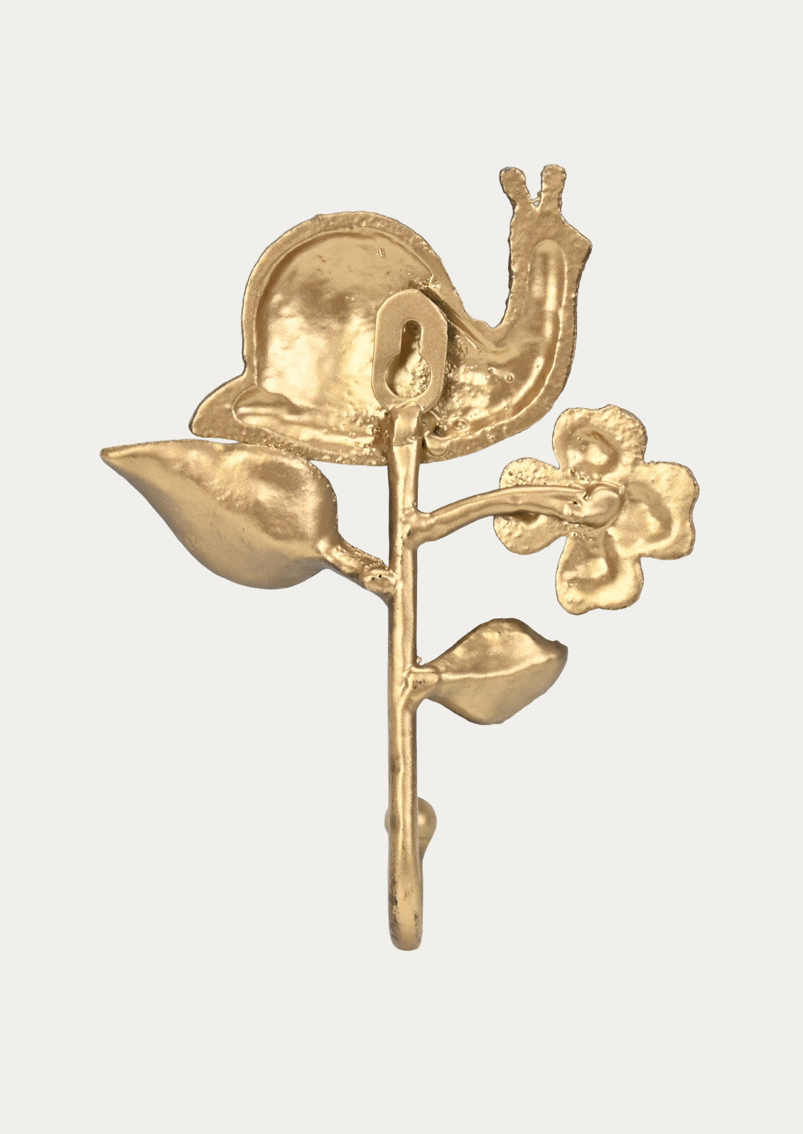 The back of a handcrafted cast iron wall hook in the shape of a snail, flower, and leaves in a gold finish on a white background.