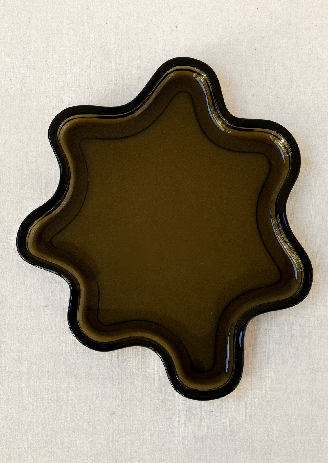 A brown glass tray in a squiggle shape.