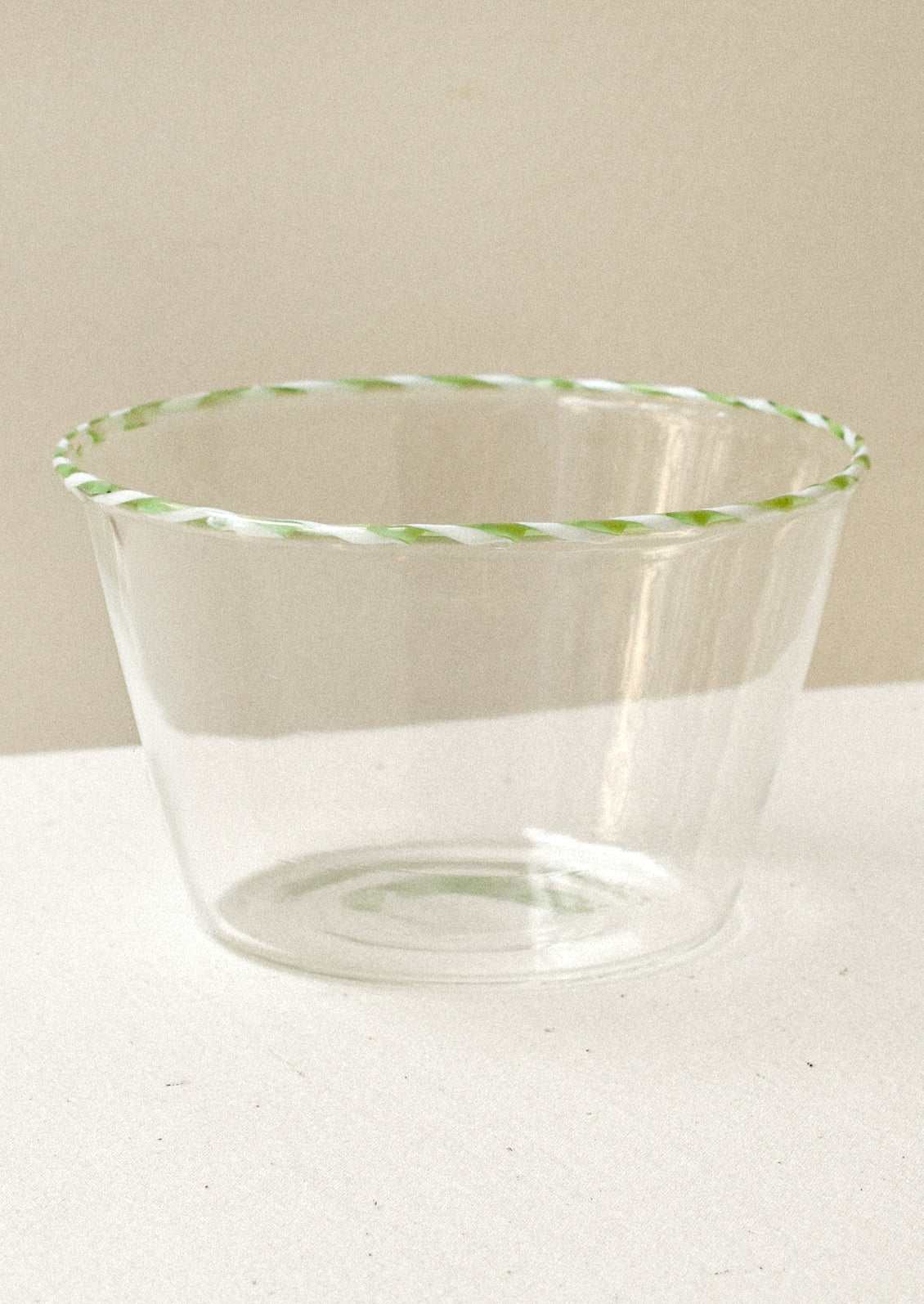 Clear glass blow with a green striped rim