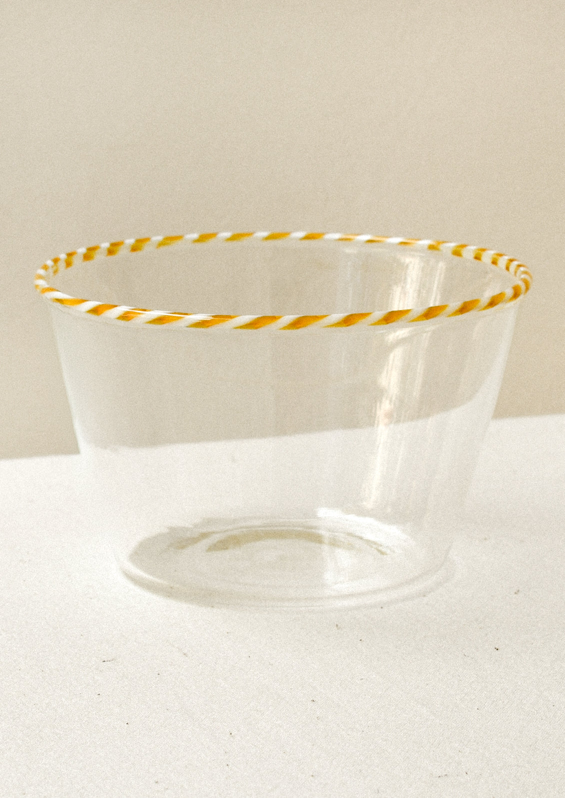 Clear glass blow with an orange striped rim