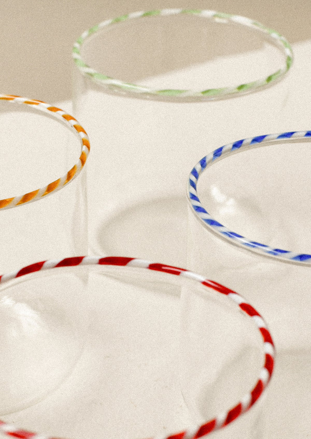 Clear glass drinking glasses with colorful striped rims