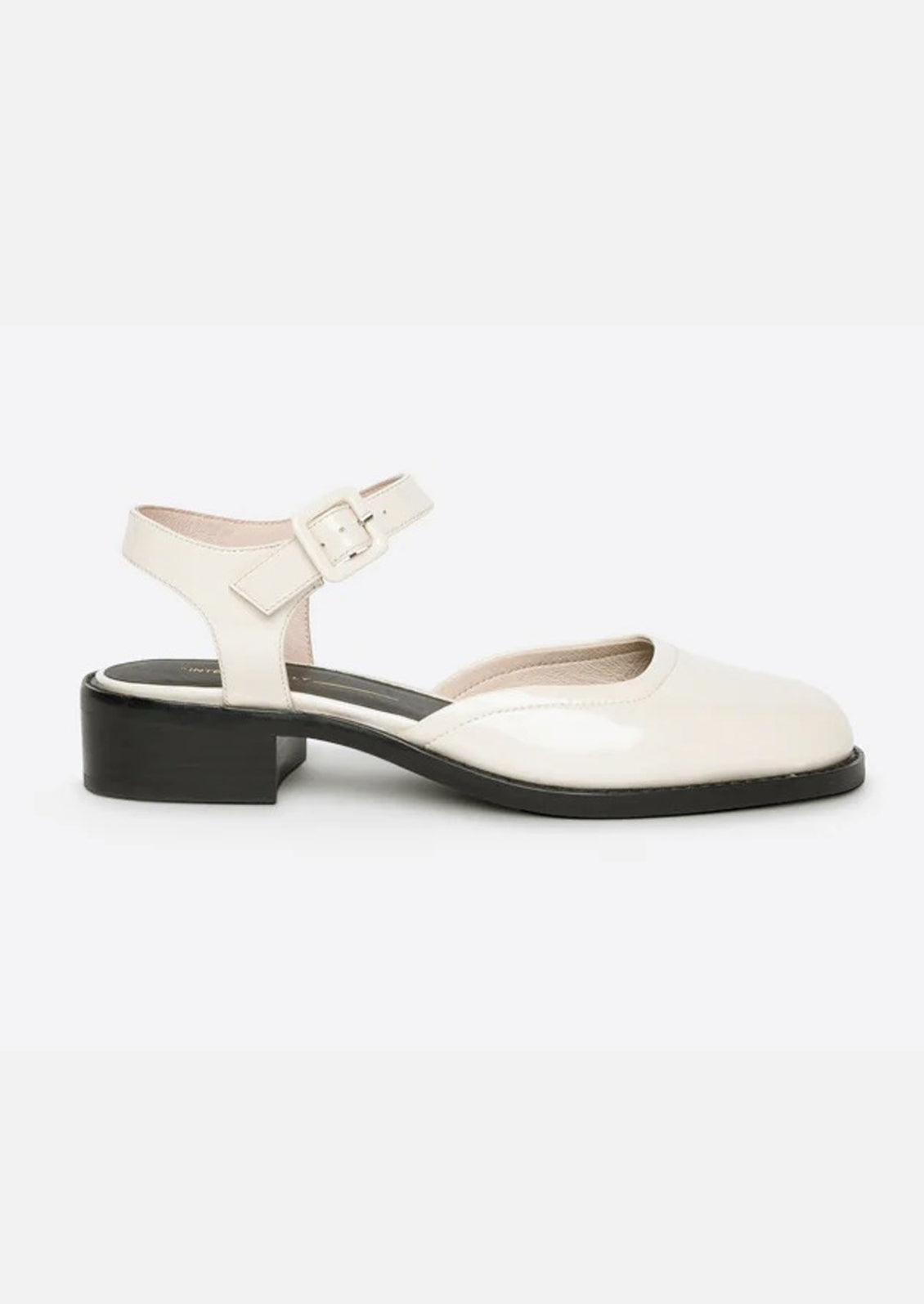 A pair of mary jane shoes with block heel in cream patent leather.