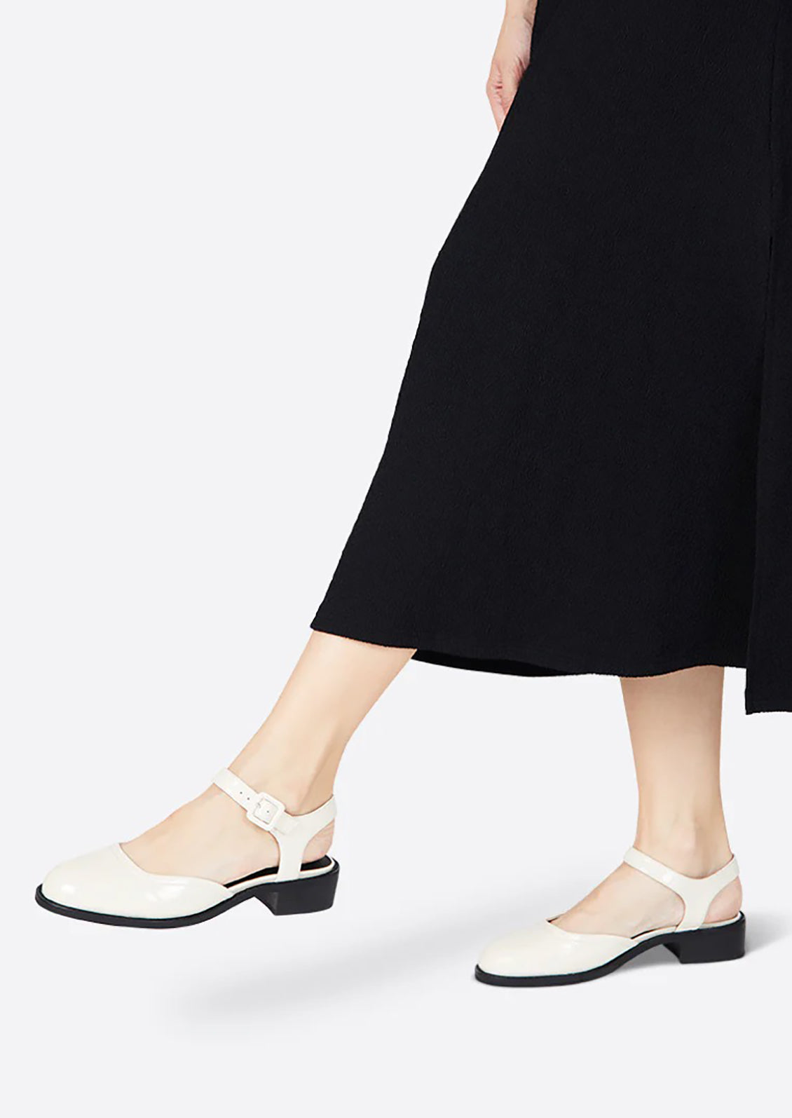 A pair of mary jane shoes with block heel in cream patent leather.
