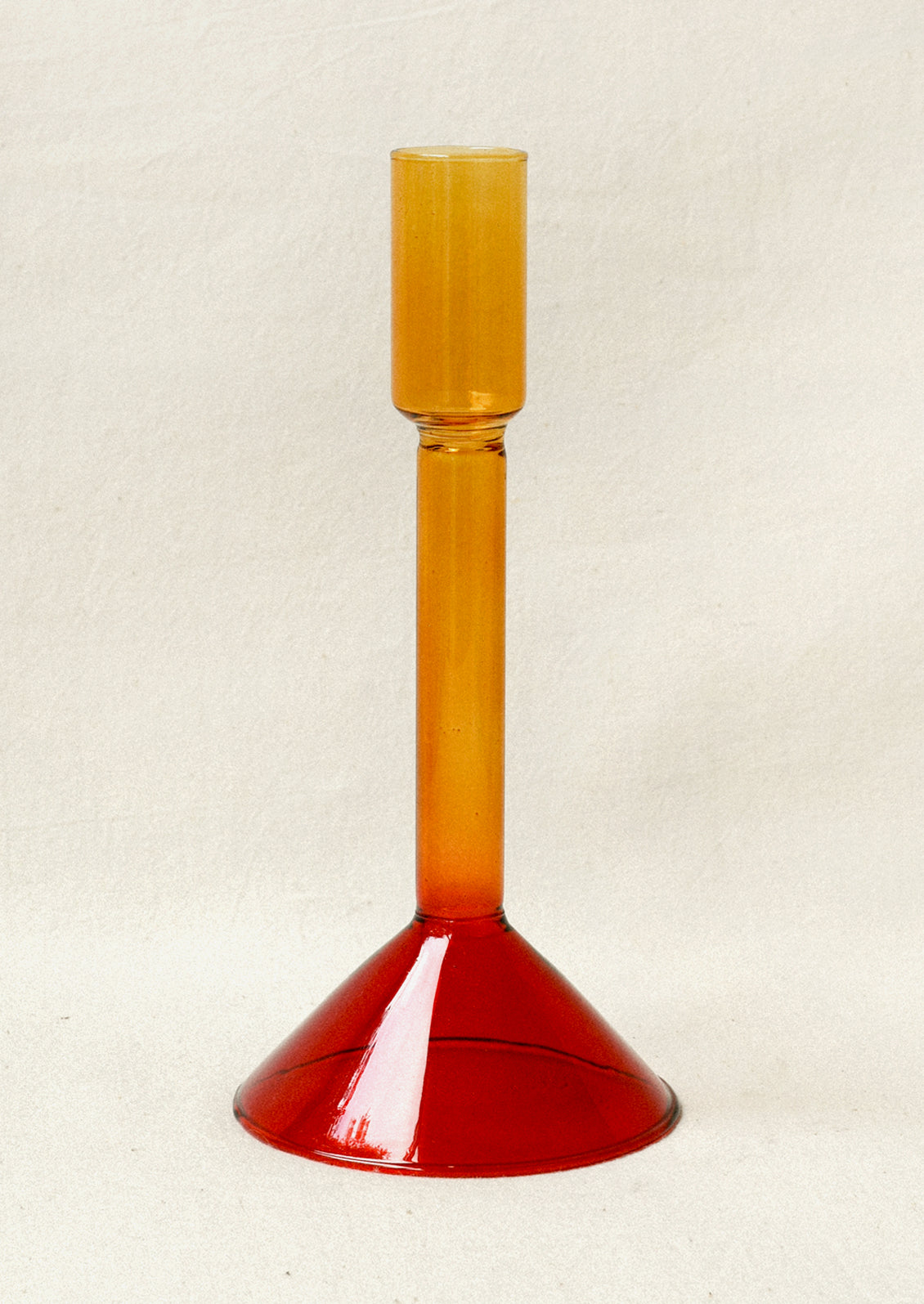 A two tone glass taper holder with an yellow stem and red base.