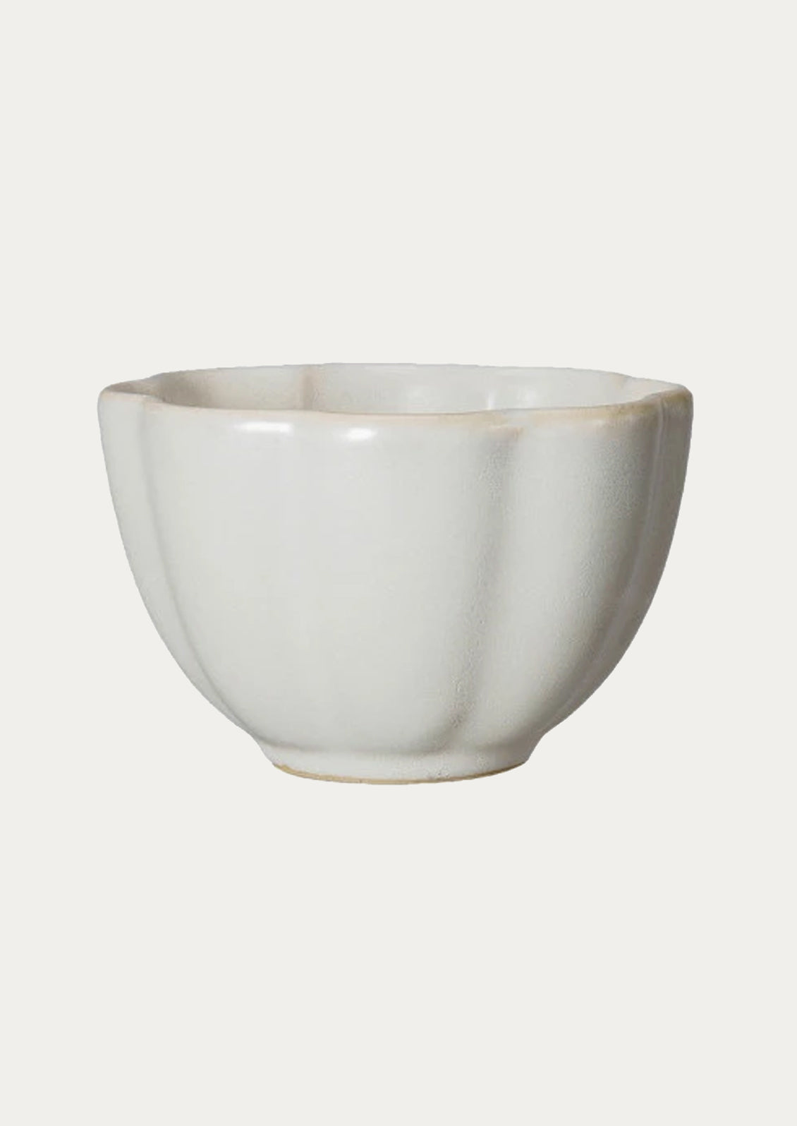 A ceramic snack bowl with scalloped shape in ivory.